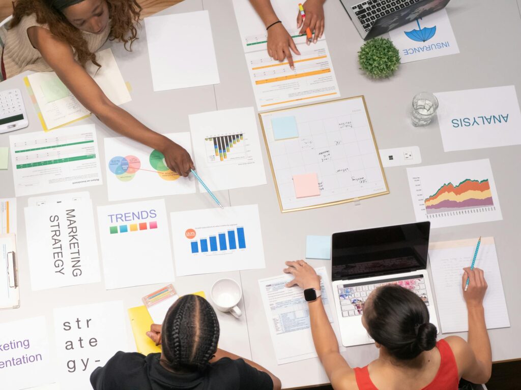 woman pointing to chart on white paper on a table 