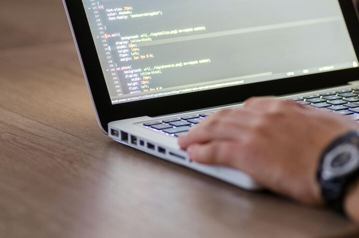 a man typing on a Macbook